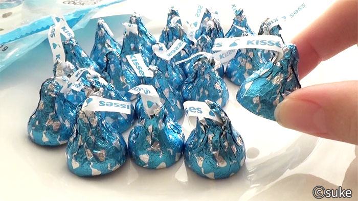 ハーシー キス・クッキー&クリームの個包装のチョコレートを一粒つまみ上げている画像
